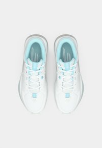 Une paire de chaussures de basketball blanches et bleu clair vue de dessus sur un fond blanc uni.