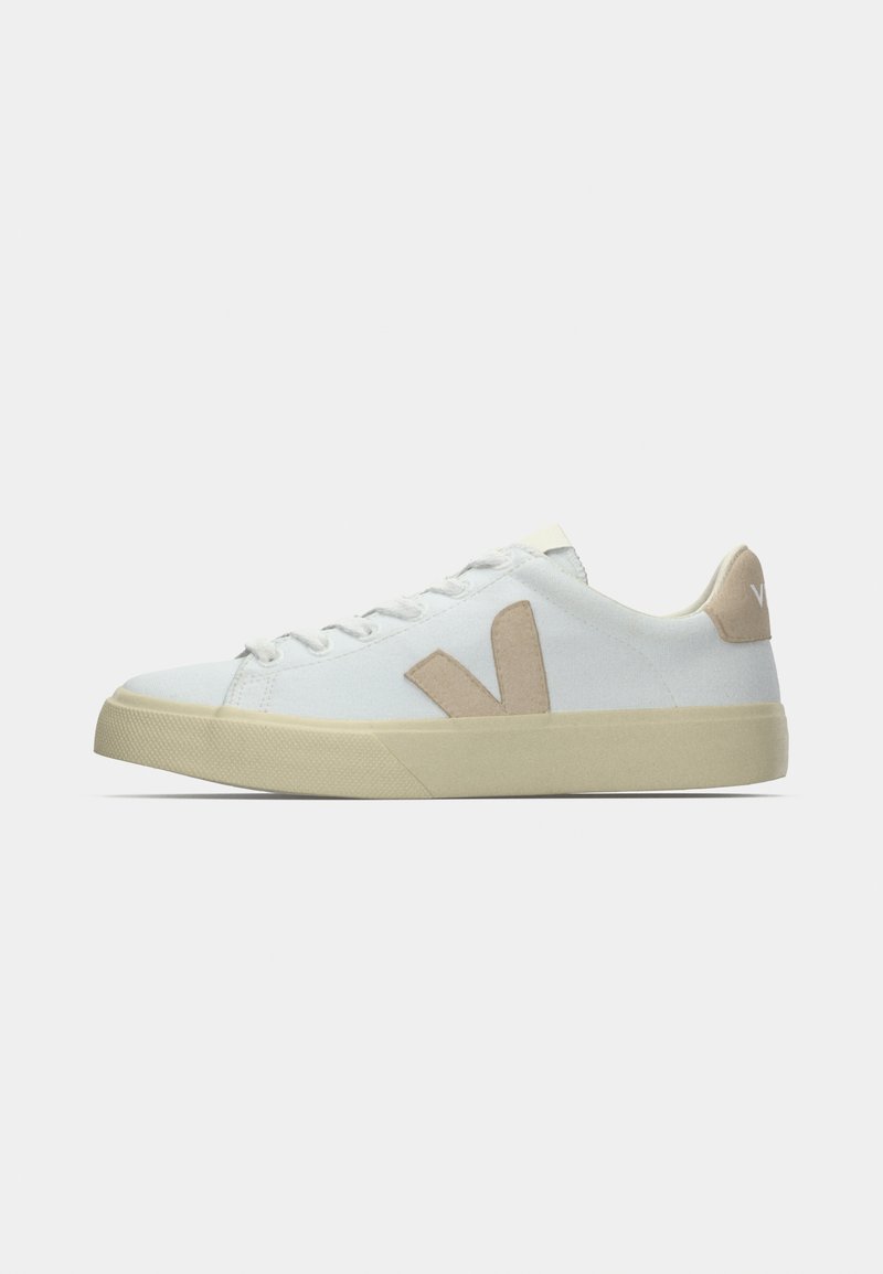 Sneakers in tela bianca con dettaglio logo beige, punta tonda, suola piatta e suola esterna in gomma strutturata. Progettate con una semplice chiusura frontale con lacci.
