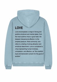 Felpa con cappuccio azzurro chiaro, caratterizzata da un grande testo nero sul retro che definisce "AMORE" e descrive i suoi significati e attributi.
