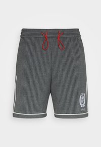 Grå stripete shorts med røde snorer, hvite detaljer på siden, og en logo-patch nederst til høyre. Mykt stoff, avslappet passform.