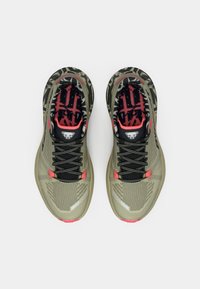 Αθλητικά παπούτσια τρεξίματος με ελαιοπράσινη διχτυωτή επάνω επιφάνεια, μαύρες κορδόνες, κόκκινες λεπτομέρειες και patterned μαύρη και γκρι σόλα. Διαθέτει λογότυπο στη γλώσσα.