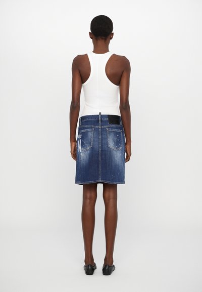 Denimrock in einem ausgebleichten Blauton mit zerstörten Details, kombiniert mit einem weißen Tanktop. Der Rock verfügt über einen klassischen Bund und Taschen.
