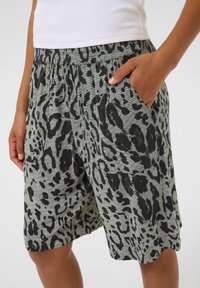 Shorts verdes con estampado de leopardo, con cintura elástica, que cuentan con bolsillos laterales y un ajuste relajado, fabricados en una tela suave y texturizada.