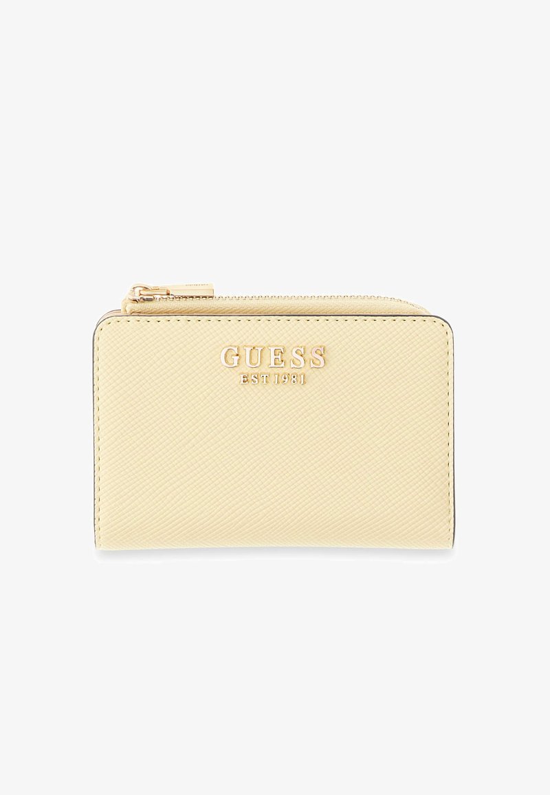 Portefeuille texturé crème avec logo doré "GUESS EST 1981" et fermeture éclair supérieure sur fond blanc.