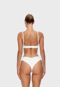 Witte bikinitopset met een bralette en hooggesneden broekjes. Het materiaal is soepel met verstelbare bandjes en een minimalistisch ontwerp.