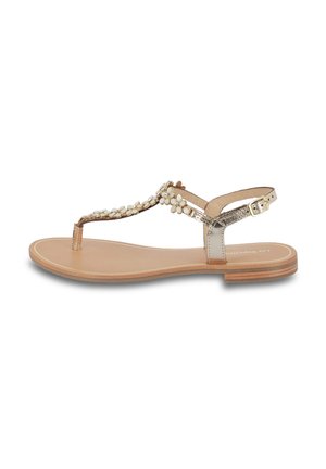 Flat sandal with a metallic gold strap, embellished with white beads, a toe post design, and a buckle closure on a brown sole.