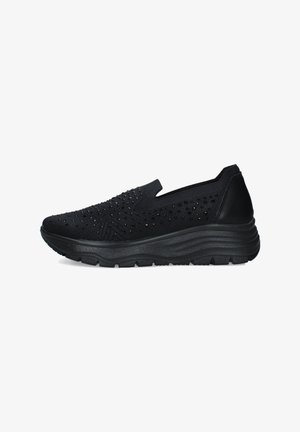 Sneaker nero slip-on con tomaia in maglia, piccole perforazioni decorative, suola spessa imbottita e battistrada strutturato, vista di profilo.