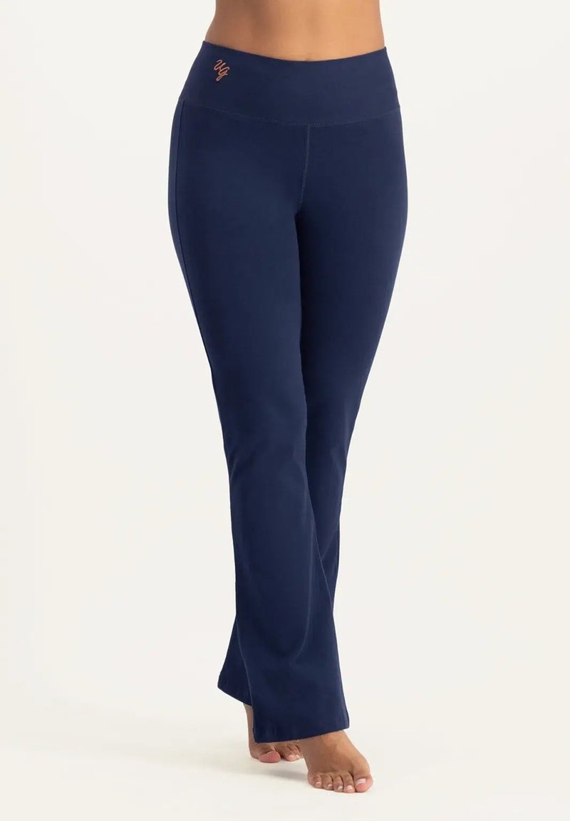 Mörkblå yogabyxor med en bred, elastisk midjeresår och platta sömmar; har en liten, orange logga framtill. Mjukt, stretchigt material.