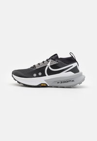 Scarpa da corsa con tomaia in mesh bianco e nero, marchio "ZoomX" ben visibile e suola grigia Vibram per una buona aderenza.
