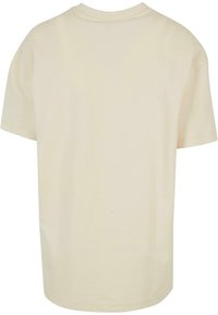 Krämfärgad t-shirt med kort ärm gjord av mjukt bomullstyg, med rund halsringning och en avslappnad passform utan synliga design detaljer.