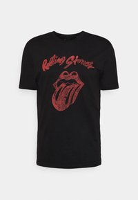 Czarny bawełniany t-shirt z wyblakłym czerwonym logo języka Rolling Stones i napisem powyżej. Krótkie rękawy oraz okrągły dekolt.