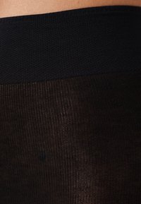 Black sheer stockings with a textured, opaque waistband. The leg portion features a fine, smooth knit that appears slightly sheer.