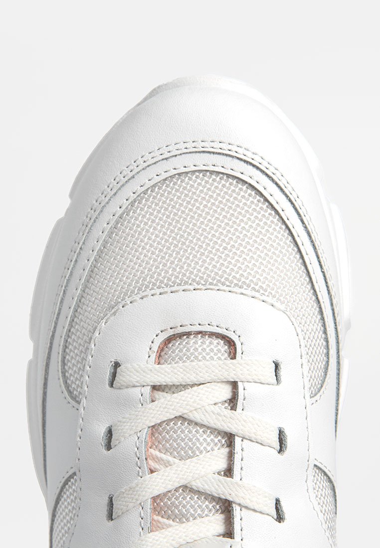 Weißer Sneaker mit strukturiertem Mesh- und glattem Lederobermaterial, flachen Schnürsenkeln und einer stabilen Gummisohle. Sichtbare Nähte.