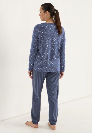 Blå pyjamasuppsättning med en långärmad topp med stjärnmönster och matchande byxor med elastisk midja, tillverkad av ett mjukt och lätt tyg.