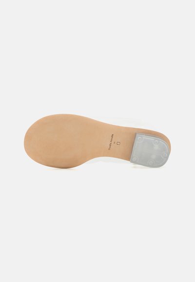 Kläbivaba tald sujuva beeži põhjaga, ümarate kontsadega ja välja tampitud brändimisega. Puhtad jooned, minimalistlik esteetika.