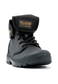 Botină neagră de glezna, cu șireturi, fabricată din țesătură texturată, având o talpă din cauciuc. Include un manșon pliabil și un patch cu logo pe limbă.