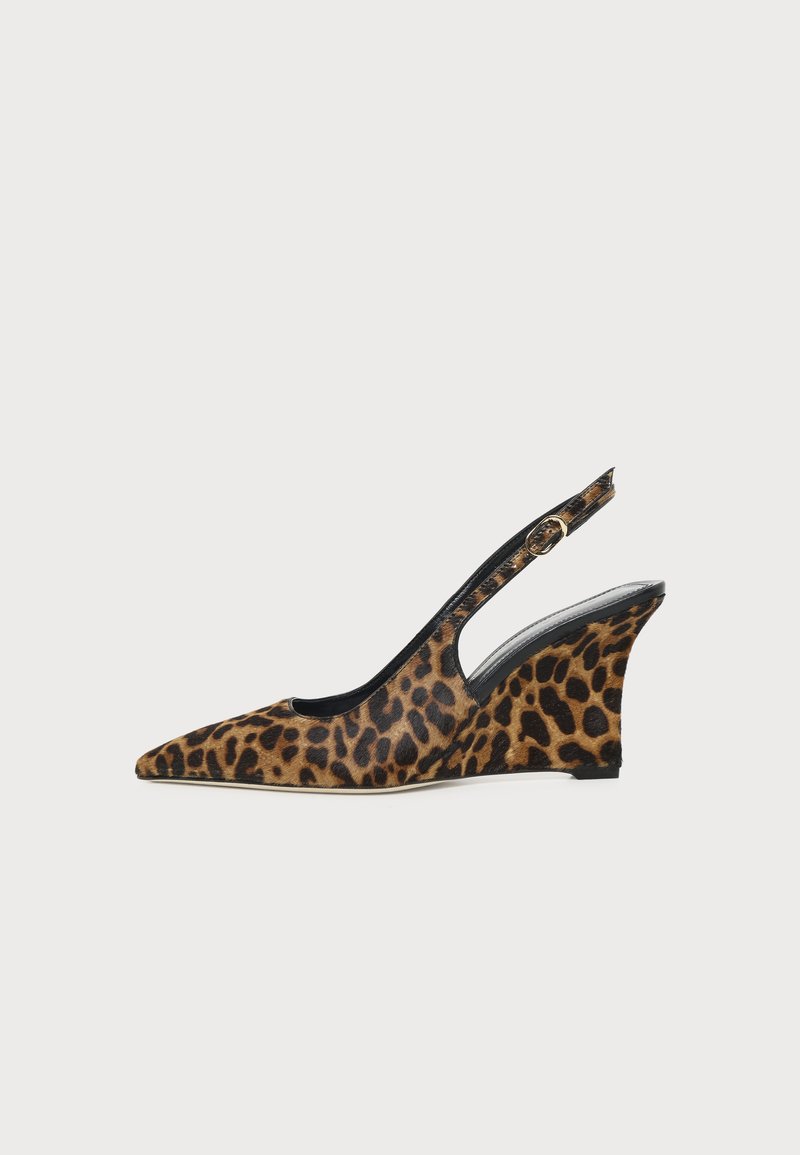 Chaussure femme à bout pointu, talon compensé imprimé léopard, bride arrière avec boucle sur fond blanc.