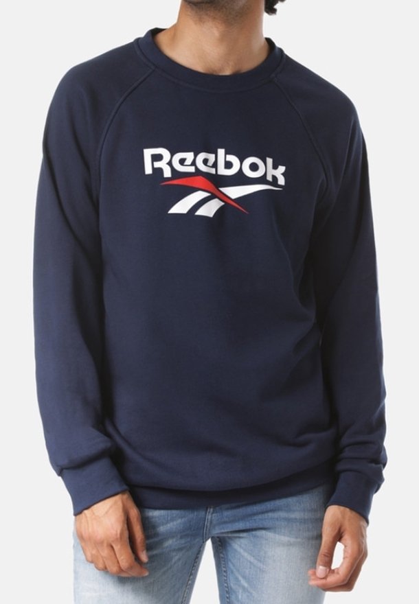 Sudadera de color azul marino hecha de algodón con cuello redondo, que presenta un logo de Reebok en blanco y rojo en el pecho y mangas raglán.