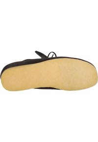 Zapato de ante negro con suela de goma amarilla clara. Presenta una forma redondeada y un diseño de cordones con un lazo para facilitar su calzado.