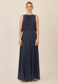 Mørkeblå plisseret maxikjole med ærmeløs design, sammenfoldet bodice og svævende nederdel. Glat, letvægtsstof med lagdelt effekt.