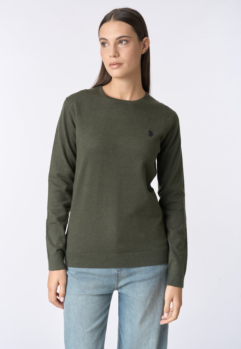 Maglione verde a maglia con scollatura rotonda, maniche lunghe e un piccolo logo nero sul lato sinistro del petto. Tessuto morbido e forma aderente.