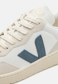 Leren sneakers met een witte bovenkant, beige suède accenten en een blauw suède 'V' logo. Bevat crèmekleurige veters en een gestructureerde rubberen zool.