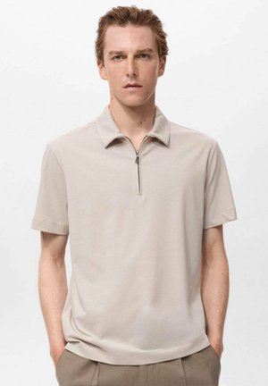 Beige short-sleeve polo shirt with a zippered collar and soft, smooth texture. Minimalist design with no visible patterns or accents.