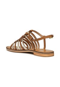 Sandalo in pelle marrone con design aperto, dotato di molteplici cinturini, suola piatta e cinturino alla caviglia regolabile per una vestibilità sicura.