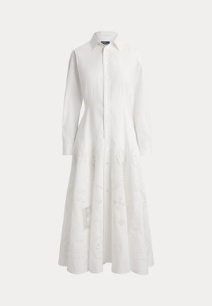 Duga bijela haljina s gumbima, ovratnicima, dugim rukavima, utegnutim strukom i suptilnim cvjetnim uzorkom s izrezima na donjem dijelu suknje.