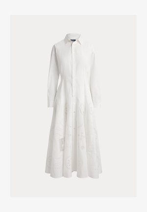 Μακρύ λευκό φόρεμα με κουμπιά, γιακάδες, μακριά μανίκια, εφαρμοστή μέση και διακριτικά λουλουδένια σχέδια με τρυπητές λεπτομέρειες στο μέρος της φούστας.