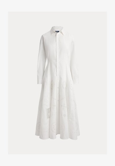 Rochie albă lungă cu nasturi, guler, mâneci lungi, talie ajustată și modele florale delicate tip broderie perforată pe partea de fustă.