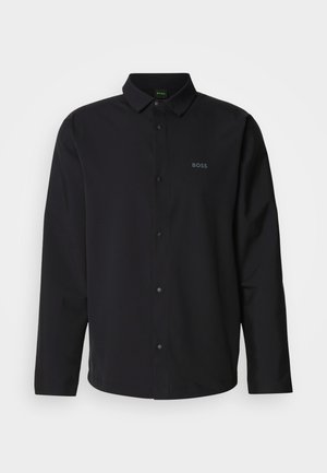 Camisa negra de manga larga con frente abotonado y cuello; presenta sutilmente el logo "BOSS" en negro a juego. Tejido suave con un ajuste entallado.