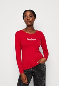 T-shirt rossa a maniche lunghe in cotone con scollatura rotonda e logo bianco "Pepe Jeans London" sul petto.