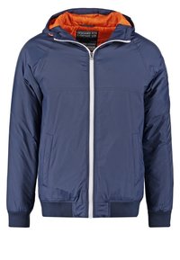 Giacca blu navy con cerniera bianca, fodera interna arancione e polsini elastici. Presenta tasche laterali e cappuccio per una maggiore protezione.