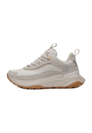 Beżowo-kremowy sportowy sneaker z teksturowaną podeszwą, sznurowanym fasonem, uchwytami na języku i pięcie oraz logo drzewa Timberland z boku.