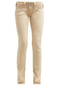 Pantalon beige slim-fit avec fermeture à double bouton, passants pour ceinture et poches avant, présenté sur fond blanc.