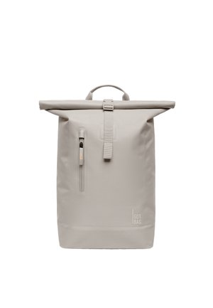 Hellgrauer Rolltop-Rucksack mit vorderer vertikaler Reißverschlusstasche, Schnallenriemen und kleinem "GOT BAG" Logo unten rechts.