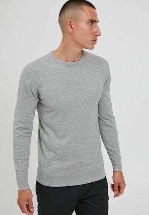 Gray, long-sleeve sweater made from soft fabric with a crew neckline and ribbed cuffs and hem, worn by a man.