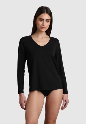 Maglietta nera a maniche lunghe in una vestibilità rilassata con scollatura a V, realizzata in tessuto morbido e con dettagli di cucitura minimi. Abbinata a un paio di pantaloni intimi neri.