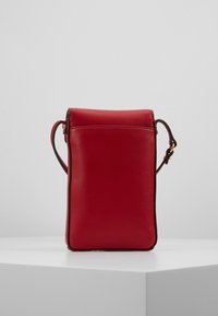 Rød læder crossbodytaske med et struktureret design, en rullet toplukning og en tynd skulderrem. Glat tekstur med minimal hardware.