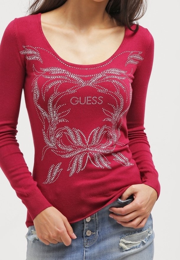 Maglietta rossa a maniche lunghe con scollatura a barchetta e grafica in strass argento che presenta design floreali e il logo "GUESS". Materiale in maglia elasticizzato.