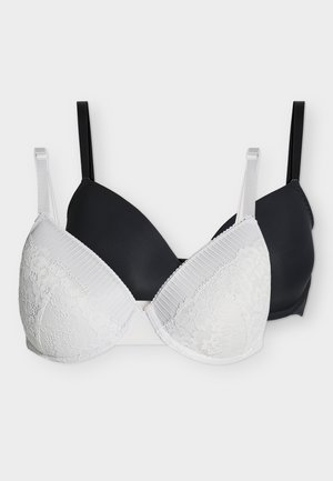 To polstrede bh'er, en hvid med blonde og en ensfarvet sort, begge med justerbare skulderstropper, vist på en ensfarvet lys baggrund.