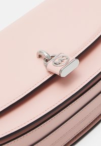 Borsa in pelle rosa con una finitura liscia, dotata di un accento a forma di lucchetto argento e cuciture nere lungo i bordi. Forma rettangolare semplice.