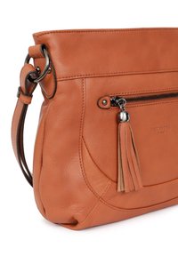 Borsa in pelle di un arancione bruciato, con una tasca con zip anteriore, un accento a frange e un design curvo con cuciture a contrasto.
