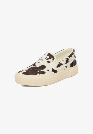 Slip-on sneaker med beige sål og sort-hvidt ko-mønstret print og hvidt logo på øverste front.
