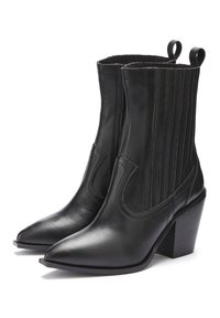 Zwarte leren enkelboots met een spitse neus, elastische zijpanelen en een gestapelde hak. Kenmerkt zich door verticale stiksels aan de zijkanten.