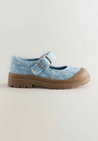 Scarpe in tessuto blu trapuntato con punta rotonda, cinturino con fibbia e suola robusta marrone con motivi di trazione. Il design include accenti floreali bianchi.