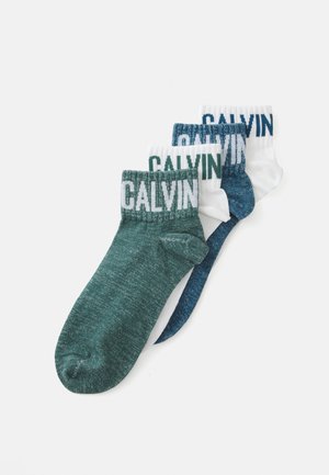 Drei Paar Knöchelsocken: dunkelgrün, marineblau und weiß; jede mit einem kontrastierenden "CALVIN"-Logo am Bündchen. Weicher Strickstoff.