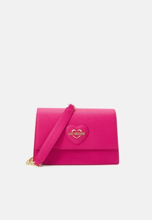 Lyserød skuldertaske med hjerteformet patch og guld "Love Moschino" logo på frontklap.