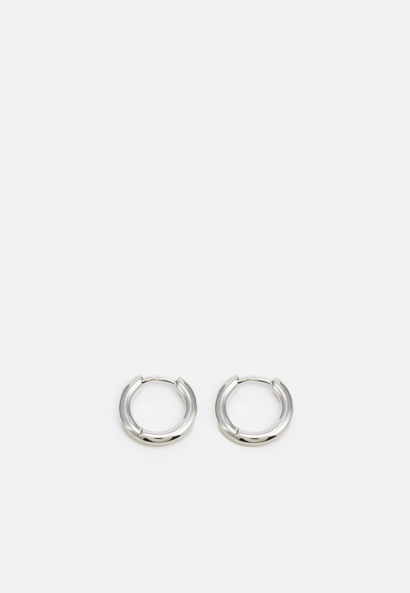 Ασημένια σκουλαρίκια σε σχήμα δαχτυλιδιού με γυαλιστερή φινιρίσματα, διαθέτοντας κυκλικό σχήμα και κλεισιμο με μεντεσέ, τονίζοντας τον κομψό και μινιμαλιστικό σχεδιασμό.